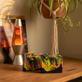 That 70s Soap rainbow-swirled black goat milk soap bars styled with a lava lamp, vinyl records, macrame, and spider plant in a groovy retro 1970s setting