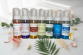 Colorful no rinse foaming hand soap bottles styled on a marble surface with tropical flowers, eucalyptus, and botanicals