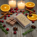 Orange Cranberry Spice wax melt clamshell packages displayed with fresh cranberries, orange slices, cinnamon sticks, star anise, rosemary sprigs, and glowing candles in warm holiday light